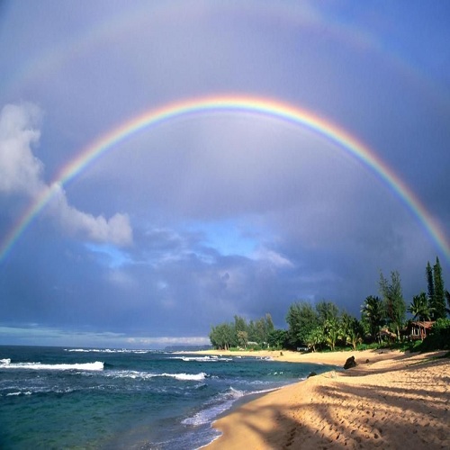 Double rainbow and evening light on beach. Kauai Island. Hawaii. USA